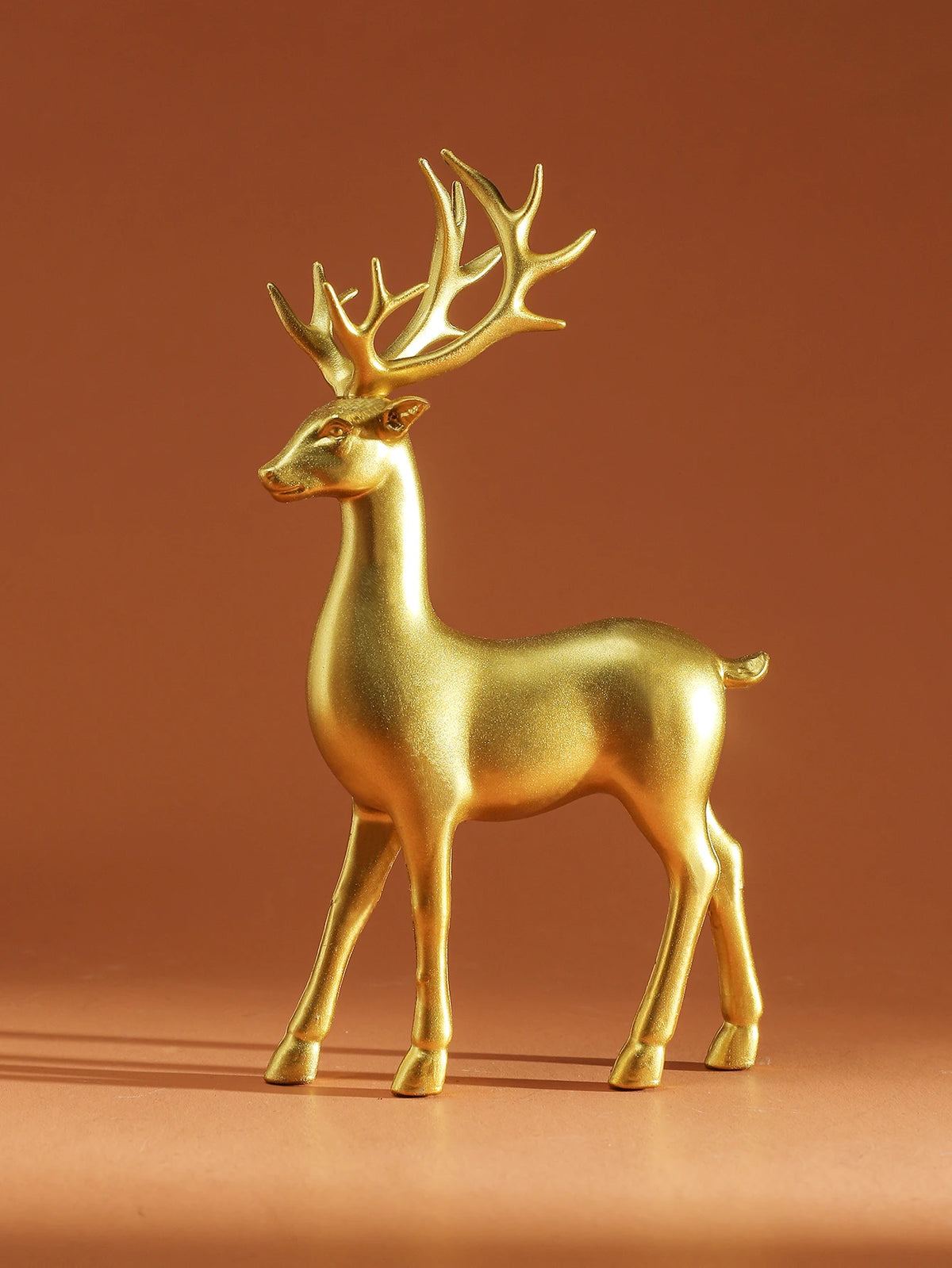 Gold deer figurine on a brown background