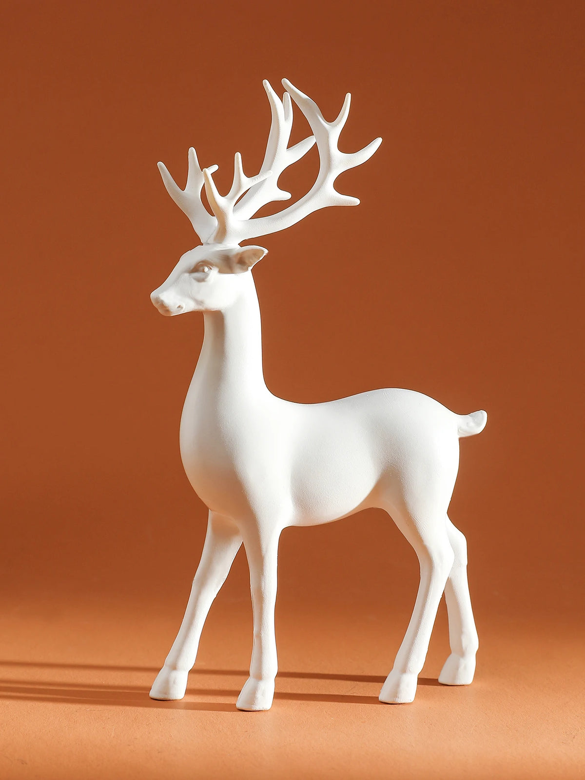 White deer figurine on a brown background