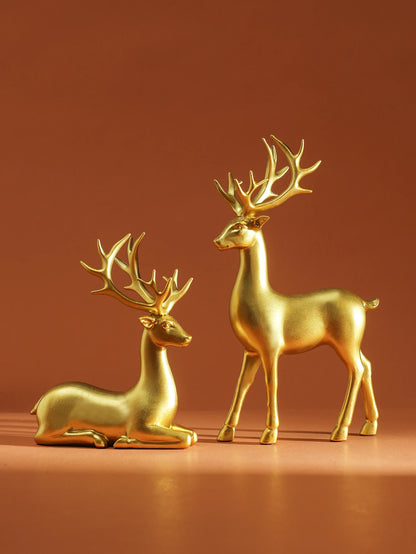 Two gold deer figurines on a brown background