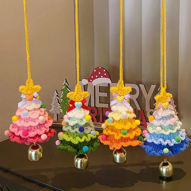 Colorful crocheted Christmas trees with pom-pom decorations on a striped background.